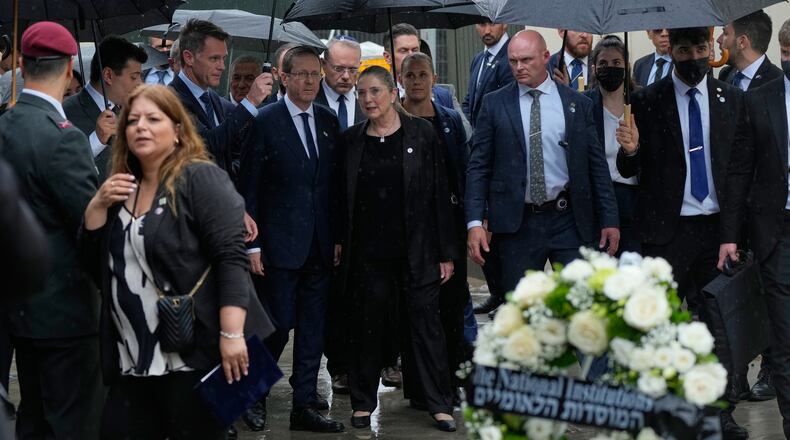 Israel's President Isaac Herzog, center left, and his wife Michal Herzog, center right, arrive at Bondi Beach for a memorial of the Dec. 2025 shooting victims, in Sydney, Monday, Feb. 9, 2026. (AP Photo/Rick Rycroft)