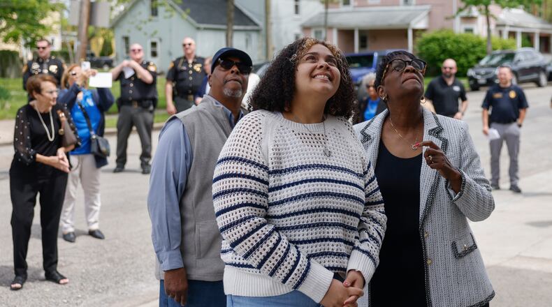 Michael Goodwin, left, Onesti Evans, center, and Sharon Evans watch the unveiling of the new title of the police sub station, named after former police chief Roger Evans during a renaming ceremony on May 7, 2025, on West Johnny Lytle Avenue. Michael, Onesti and Sharon are the nephew, granddaugther and wife of Roger, respectfully, who died in 2024. JOSEPH COOKE/STAFF