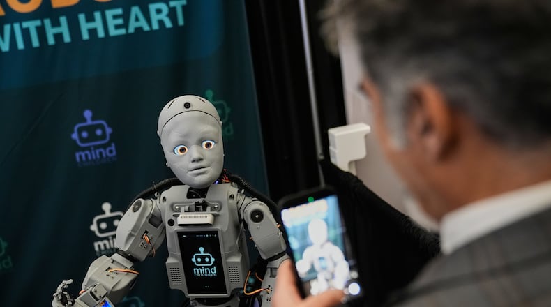 A man records a humanoid robot inside the exhibition room at the Humanoids Summit, Thursday, Dec. 11, 2025, in Mountain View, Calif. (AP Photo/Godofredo A. Vásquez)