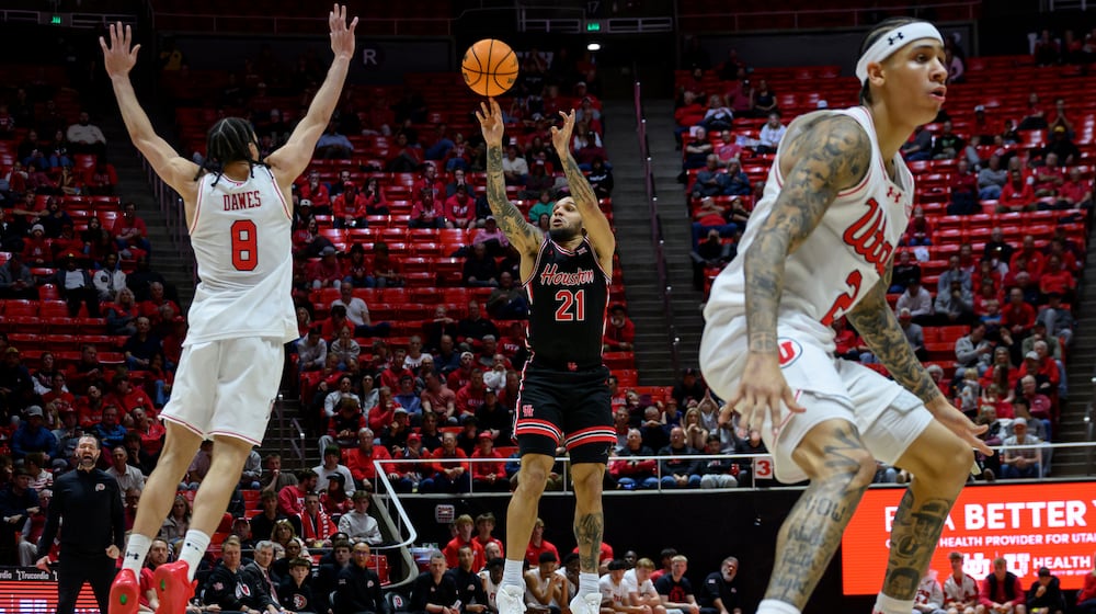 Houston guard Emanuel Sharp (21) shoots over Utah forward Keanu Dawes (8) during the second half of an NCAA college basketball game, Tuesday, Feb. 10, 2026, in Salt Lake City. (AP Photo/Tyler Tate)