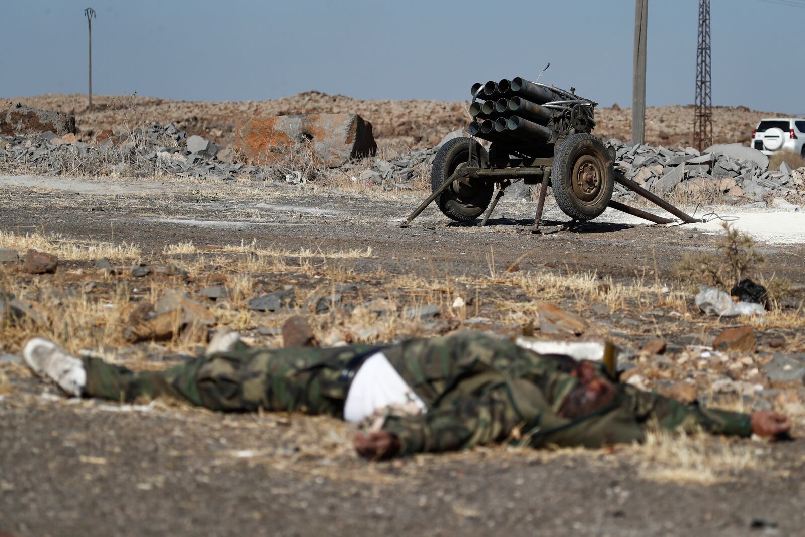 A dead fighter of the Druze militias lies on the ground in front of a rocket launcher on the outskirts of Sweida city, where clashes erupted between Sunni Bedouin clans and Druze militias, southern Syria, Monday, July 14, 2025. (AP Photo/Omar Sanadiki)