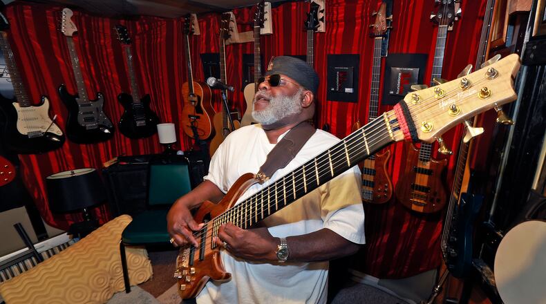 Larry Humphrey, surrounded by his axes, in his current basement studio. BILL LACKEY / STAFF