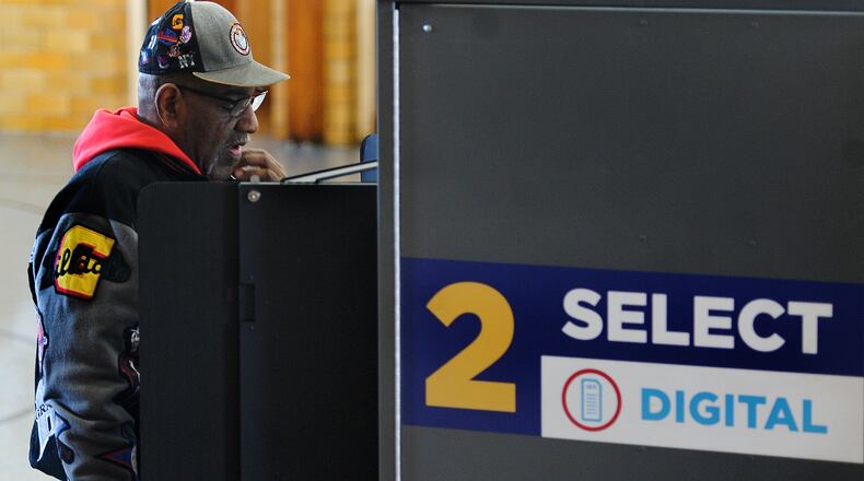 Guy Sanford reads over his ballot, March 19, 2024 at the Grace United Methodist Church in Dayton. This year, early voting begins on Oct. 7. MARSHALL GORBY / STAFF
