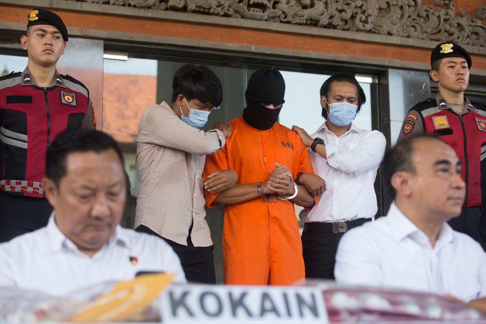 An Australian man arrested for allegedly smuggling cocaine stands after escorted to a news conference at the police headquarters in Bali, Indonesia, Monday, May 26, 2025. (AP Photo/Firdia Lisnawati)