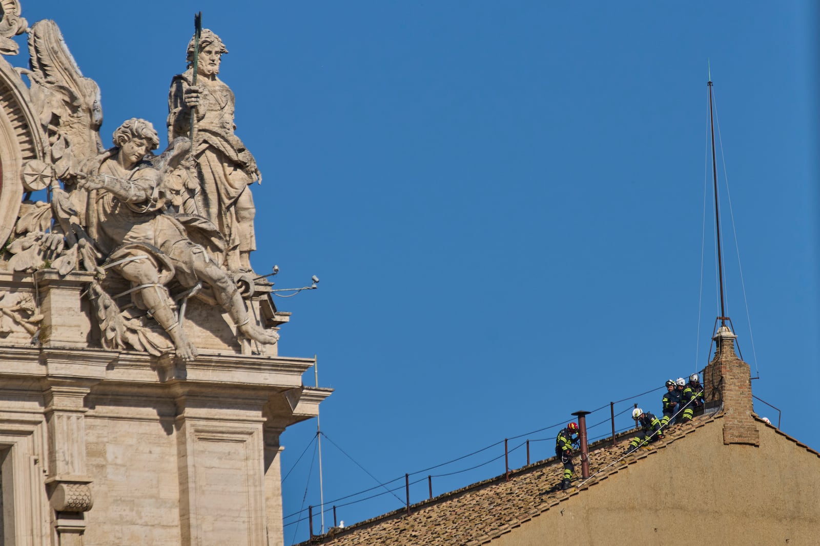 Firefighters place the chimney on the roof of the Sistine Chapel, where cardinals will gather to elect the new pope, at the Vatican, Friday, May 2, 2025. (AP Photo/Bernat Armangue)