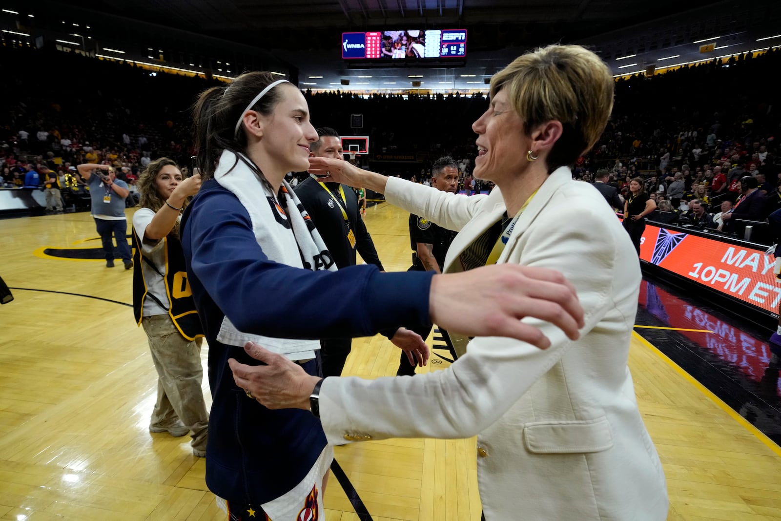 Indiana Fever guard Caitlin Clark, left, hugs Iowa coach Jan Jensen, right, after an exhibition women's basketball game against Brazil, Sunday, May 4, 2025, in Iowa City, Iowa. (AP Photo/Charlie Neibergall)