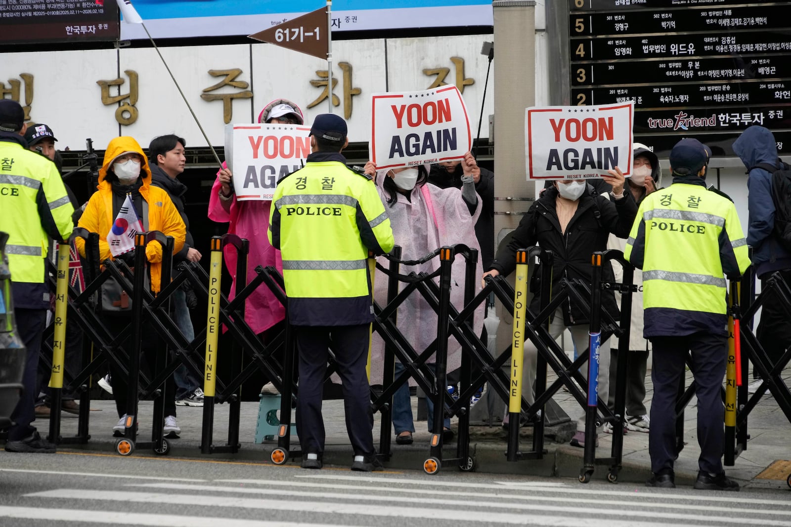 Supports of South Korea's ousted President Yoon Suk Yeol stand to call for the cancellation of his removal in front of the Seoul Central District Court in Seoul, South Korea, Monday, April 14, 2025. (AP Photo/Ahn Young-joon)
