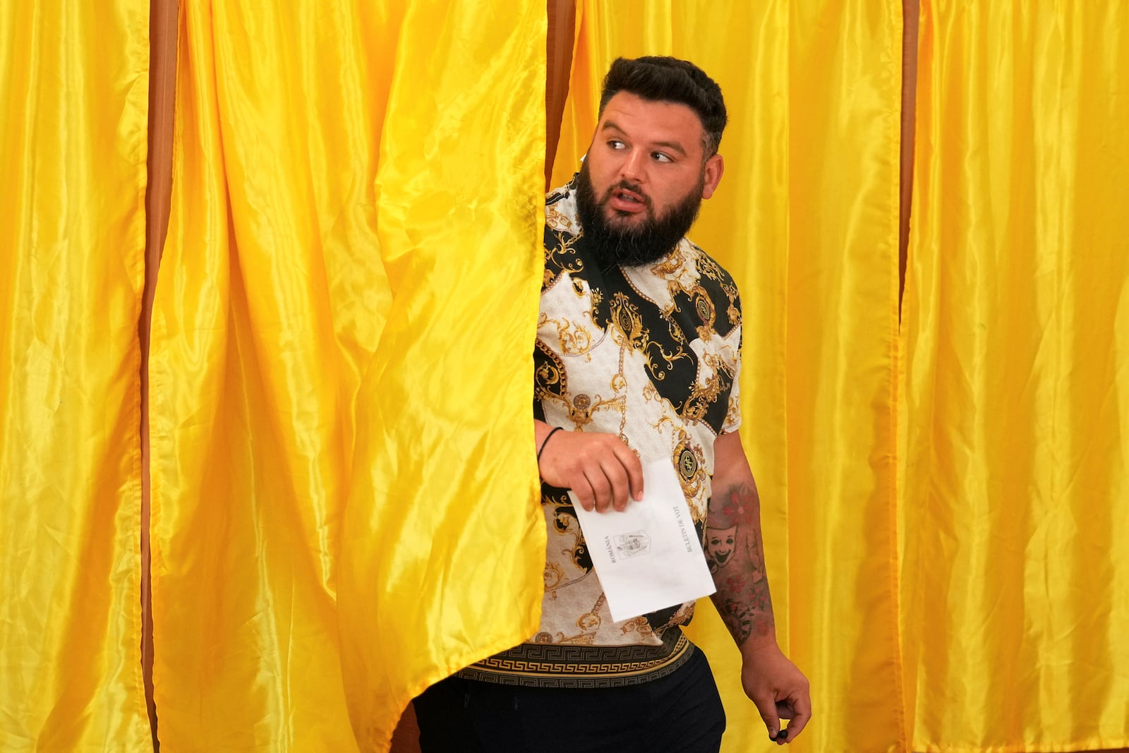 A man exits a voting cabin before casting his vote in the first round of the presidential election redo in Mogosoaia, Romania, Sunday, May 4, 2025. (AP Photo/Vadim Ghirda)