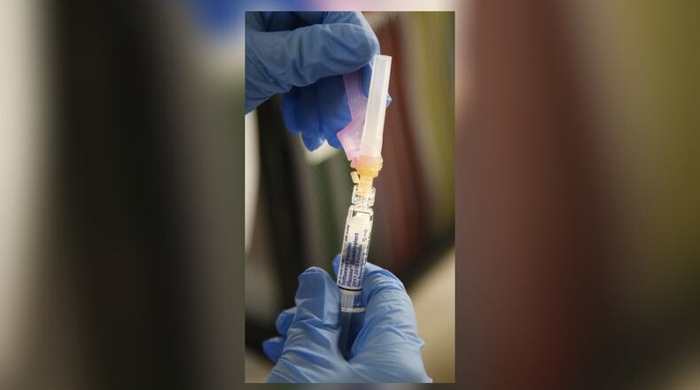 Nurse Debbie Parker prepares flu vaccine for patients at the Montgomery County Public Health Clinic in downtown Dayton. Flu numbers continue to climb in 2018. TY GREENLEES / STAFF