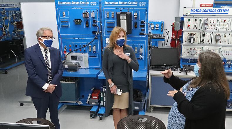 Clark State College students will receive their first round of tuition reimbursements from the H-1B One Workforce Grant Program this fall. Here, Engineering Professor Nora Hatem, right, talked about one of the labs as she and President Jo Alice Blondin, center, give Gov. Mike DeWine a tour of their Advanced Manufacturing Lab last year. BILL LACKEY/STAFF