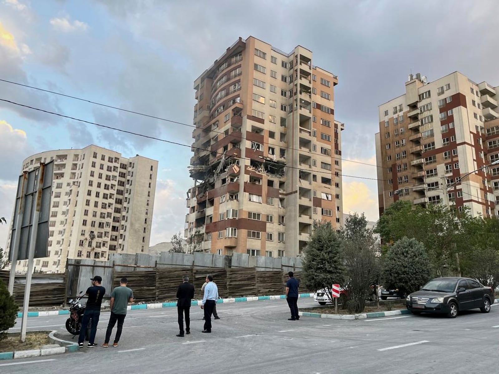 Residents watch a damaged apartment in Tehran, Iran, early Friday, June 13, 2025. Israel attacked Iran's capital early Friday, with explosions booming across Tehran.(AP Photo/Vahid Salemi)