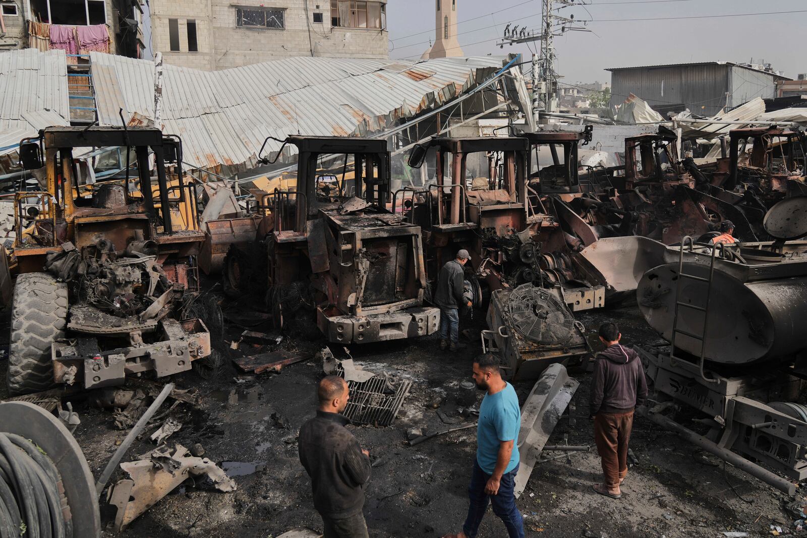 Palestinians examine the remains of bulldozers hit by an Israeli army airstrike in Jabaliya, northern Gaza Strip, on Tuesday, April 22, 2025. (AP Photo/Jehad Alshrafi)