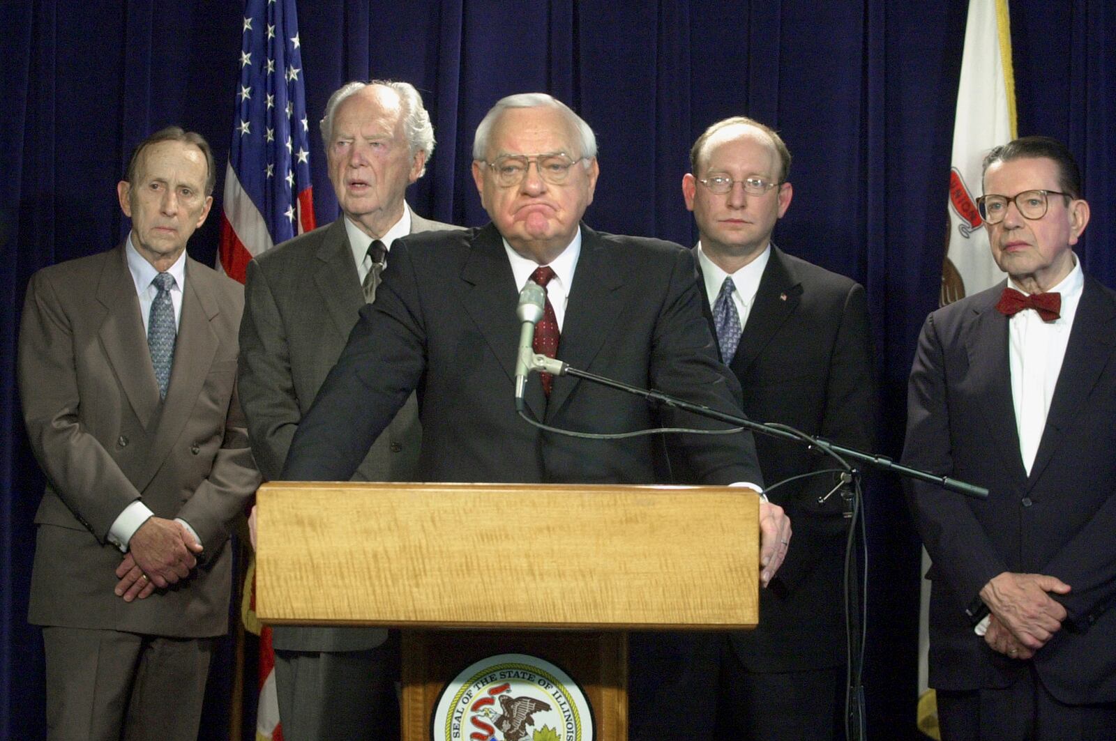 FILE - Gov. George Ryan listens to a reporter's question after a report by a state panel on capital punishment, formed two years earlier by Ryan, was released in Chicago during a news conference Monday, April 15, 2002. Looking on, from left, are commission members Thomas Sullivan, Judge Frank McGarr, Matt Bettenhausen and former U.S. Sen. Paul Simon. (AP Photo/M. SpencerGreen, File)