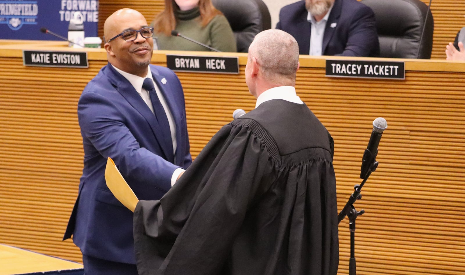 New Springfield City Commissioner Chris Wallace shakes hands with Clark County Common Pleas Court Judge Douglas Rastatter after he swears him in Friday, Jan. 2, 2026. JESSICA OROZCO/STAFF