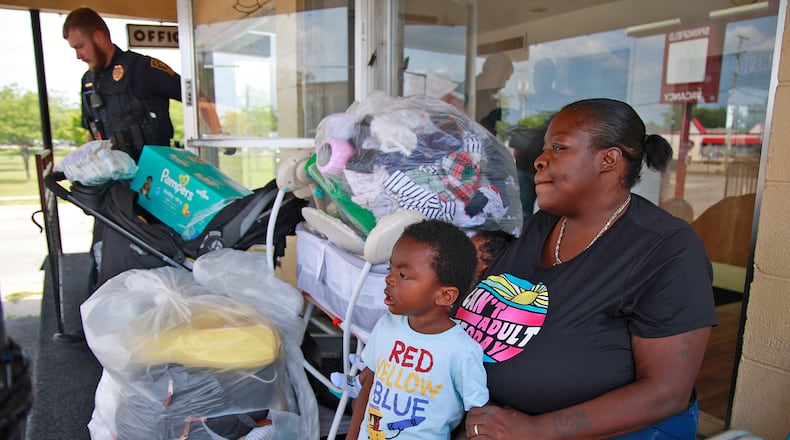 Roena Cole sits outside the office at the Executive Inn homeless shelter with all her grandson's belongings after being told she, her daughter and grandson had to leave Tuesday, August 6, 2024. BILL LACKEY/STAFF