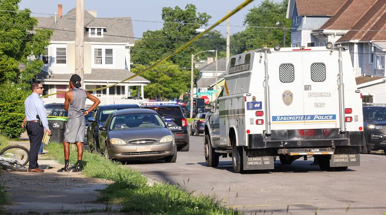 A Springfield police detective talks to a man on East Cecil Street on Wednesday, July 23, 2025. Police were responding to a shooting. BRYANT BILLING / STAFF