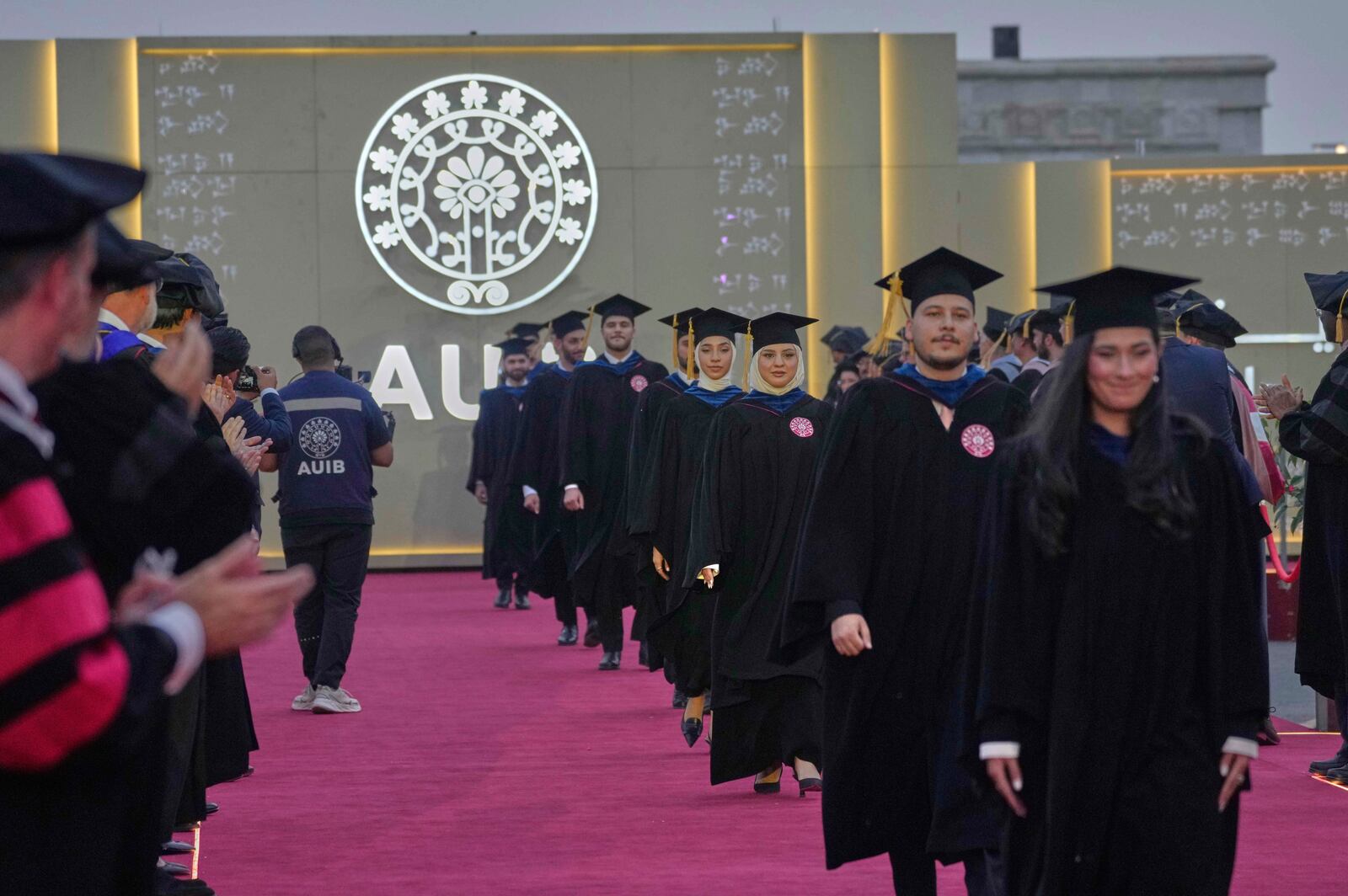 The American University of Iraq - Baghdad students stand together during the first graduation for the school in Baghdad, Iraq, Saturday, May 24, 2025. (AP Photo/Hadi Mizban)