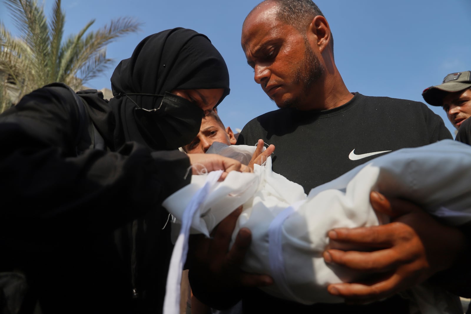 Ahmed Abu Halib and his wife Esraa Abu Halib, left, mourn over the body of their 5-month-old baby, Zainab, who died from malnutrition-related causes, according to the family, during her funeral outside the Nasser Hospital, in Khan Younis, Saturday, July 26, 2025. (AP Photo/Mariam Dagga)