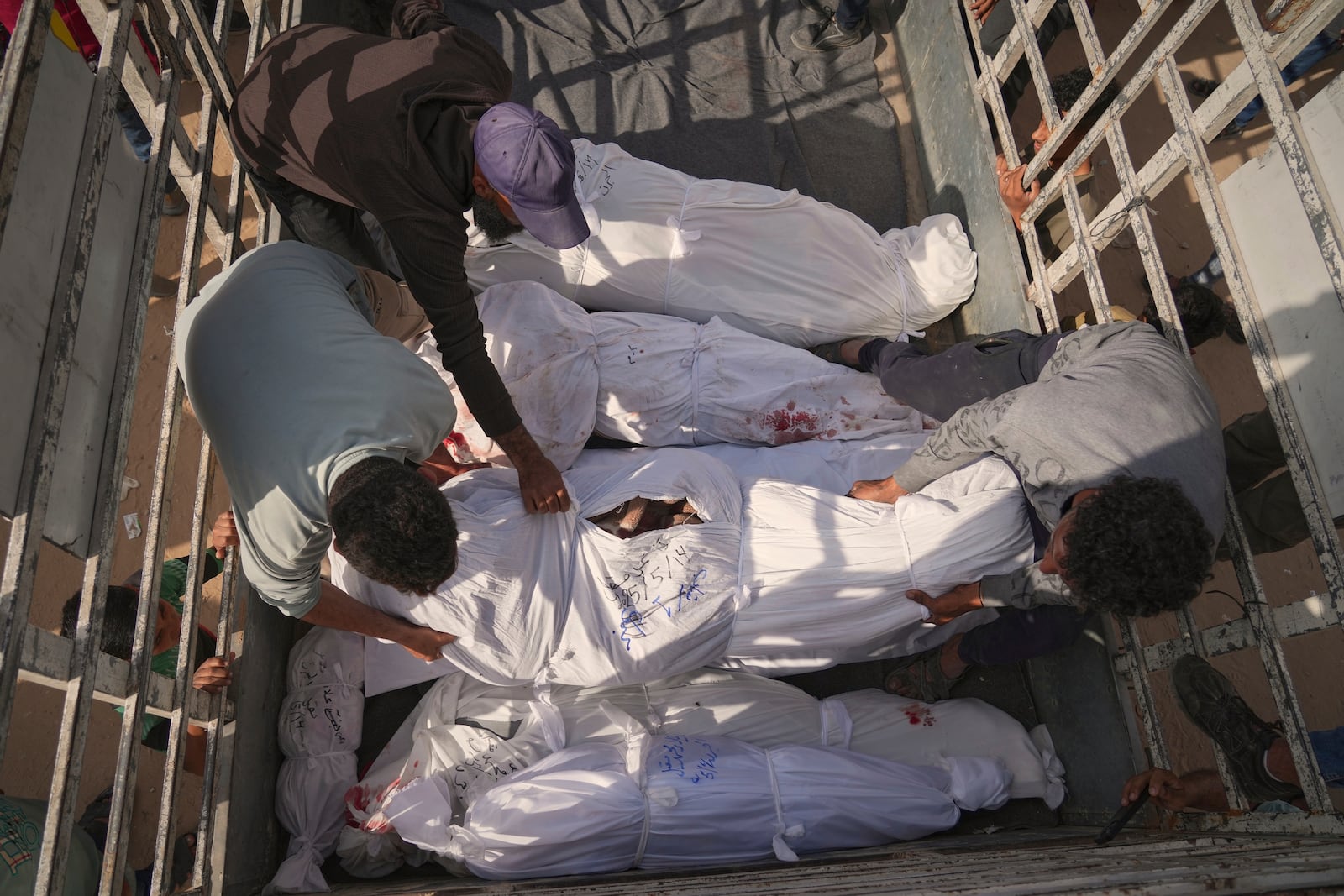 Palestinians load bodies of their relatives killed in the Israeli army airstrikes in Jabalia, northern Gaza Strip, on Wednesday, May 14, 2025. According to local hospitals, 48 people were killed in the strikes, including 22 children. (AP Photo/Jehad Alshrafi)