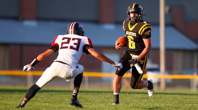 Shawnee High School quarterback Drew Mitch runs the ball as Bellefontaine’s Jaeden Campbell waits to tackle him during their game on Friday night in Springfield. The Braves won 13-6 in overtime. Michael Cooper/CONTRIBUTED