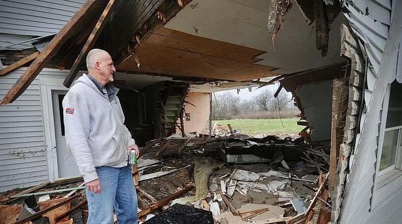 Dave Fisher looks at what is left of his house on Friday, March 31, 2023, after a semi drove through it Thursday evening at state Routes 571 and 201 in Bethel Twp. Fisher’s wife was inside and only suffered minor injuries, but the house will be demolished and rebuilt, Fisher says. MARSHALL GORBY \STAFF