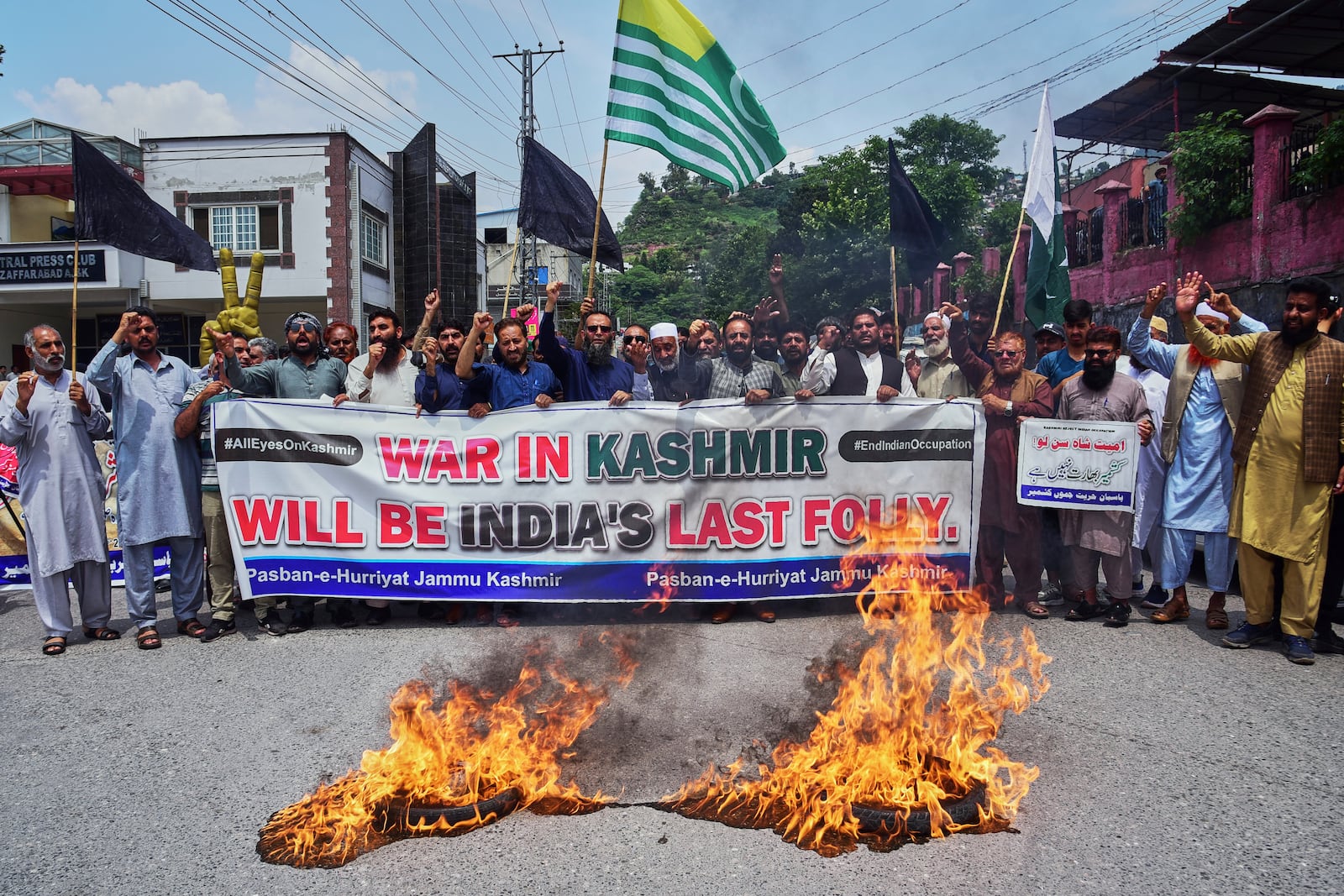 Supporters of Pasban-e-Hurriyat Jammu and Kashmir chant slogans next to burning tires during an anti-India demonstration, in Muzaffarabad, the capital of Pakistan administered Kashmir, Monday, May 5, 2025. (AP Photo/M.D. Mughal)