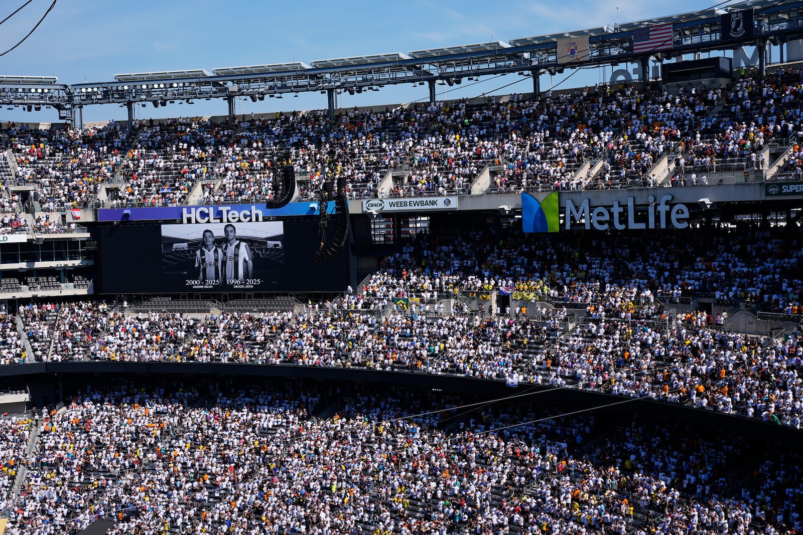 Fans observe a minute of silent in memory of Portugal international and Liverpool player Diogo Jota and his brother Andre Silva, prior the Club World Cup quarterfinal soccer match between Real Madrid and Borussia Dortmund in East Rutherford, N.J., Saturday, July 5, 2025. (AP Photo/Pamela Smith)