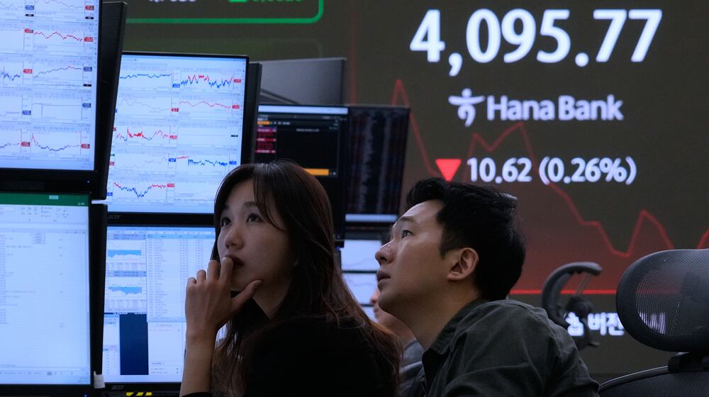 Currency traders watch monitors near a screen showing the Korea Composite Stock Price Index (KOSPI) at the foreign exchange dealing room of the Hana Bank headquarters in Seoul, South Korea, Wednesday, Nov. 12, 2025. (AP Photo/Ahn Young-joon)