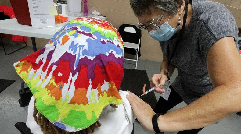 Peggy Smith, a registered nurse, gives a COVID vaccine at the Clark County Combined Health District's vaccine center on Leffel Lane. BILL LACKEY/STAFF