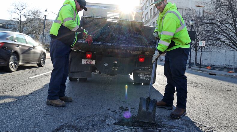 City of Springfield crews patch potholes along High Street in downtown Springfield during a previous street repair cycle. BILL LACKEY/STAFF
