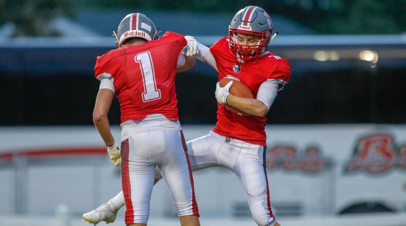 Southeastern High School senior Duke McCombs (right) celebrates with senior Nick Harris after catching a touchdown pass during their game on Friday night at Trojan Stadium in South Charleston. The Trojans won 34-0. Michael Cooper/CONTRIBUTED