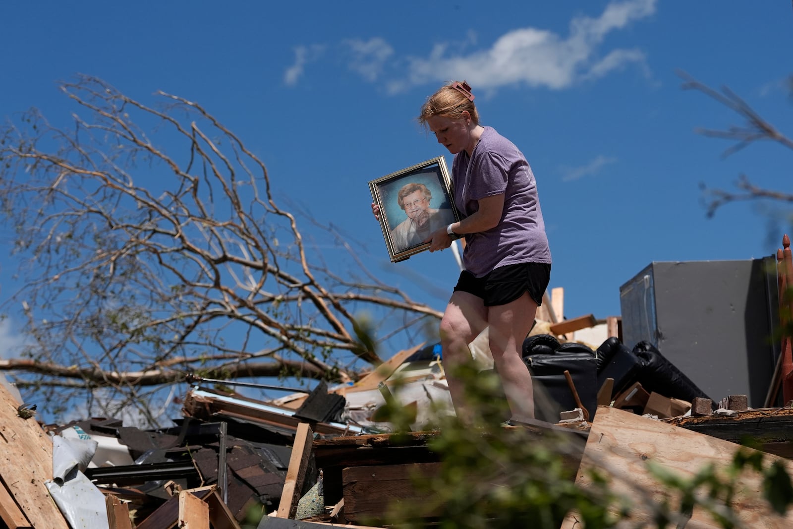 Hailee Allen holds a family picture saved from Lynn and Don White's home, Saturday, May 17, 2025, in London, Ky (AP Photo/Carolyn Kaster)
