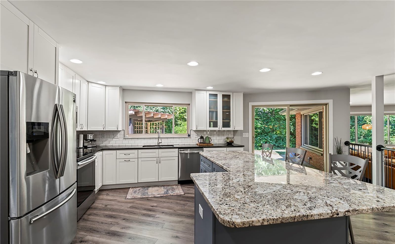 The completely updated kitchen features new cabinets with granite countertops and an island with bar seating. It has recessed lighting and a sliding glass door opening to the flagstone patio. CONTRIBUTED