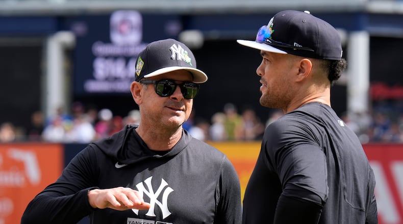 New York Yankees manager Aaron Boone, left, talks to designated hitter Giancarlo Stanton as he waits to take batting practice during a spring training baseball workout Monday, Feb. 16, 2026, in Tampa, Fla. (AP Photo/Chris O'Meara)