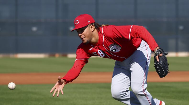 Cincinnati Reds starting pitcher Luis Castillo flips the ball to home plate during spring training baseball workouts Monday, Feb. 17, 2020, in Goodyear, Ariz. (AP Photo/Ross D. Franklin)