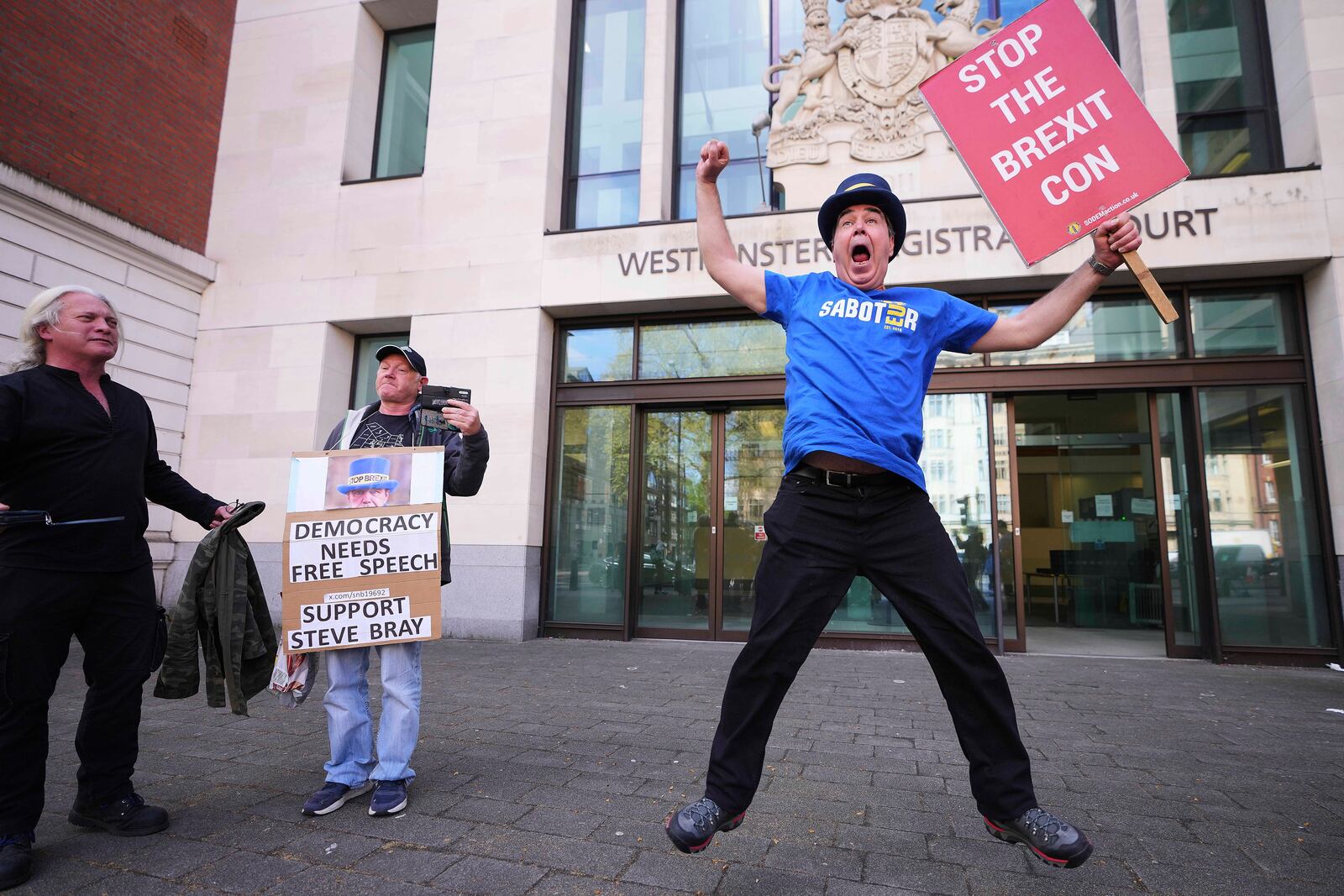 Anti-Brexit campaigner Steve Bray celebrates as he leaves Westminster Magistrates Court in London, Monday, April 14, 2025, after he has been found not guilty to failing without reasonable excuse to comply with a direction given under the Police Reform and Social Responsibility Act 2011. (AP Photo/Kirsty Wigglesworth)