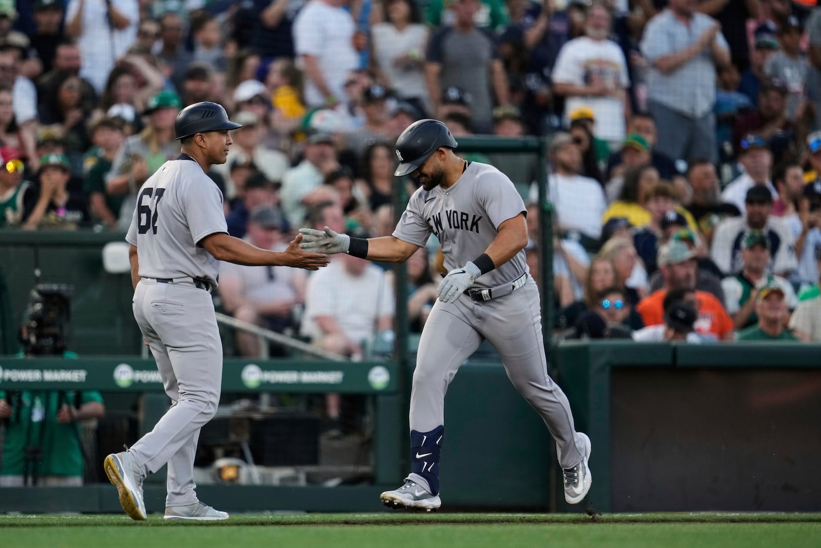 New York Yankees' Jasson Domínguez, right, celebrates with third base coach Luis Rojas after hitting a solo home run during the third inning of a baseball game against the Athletics, Friday, May 9, 2025, in West Sacramento, Calif. (AP Photo/Godofredo A. Vásquez)