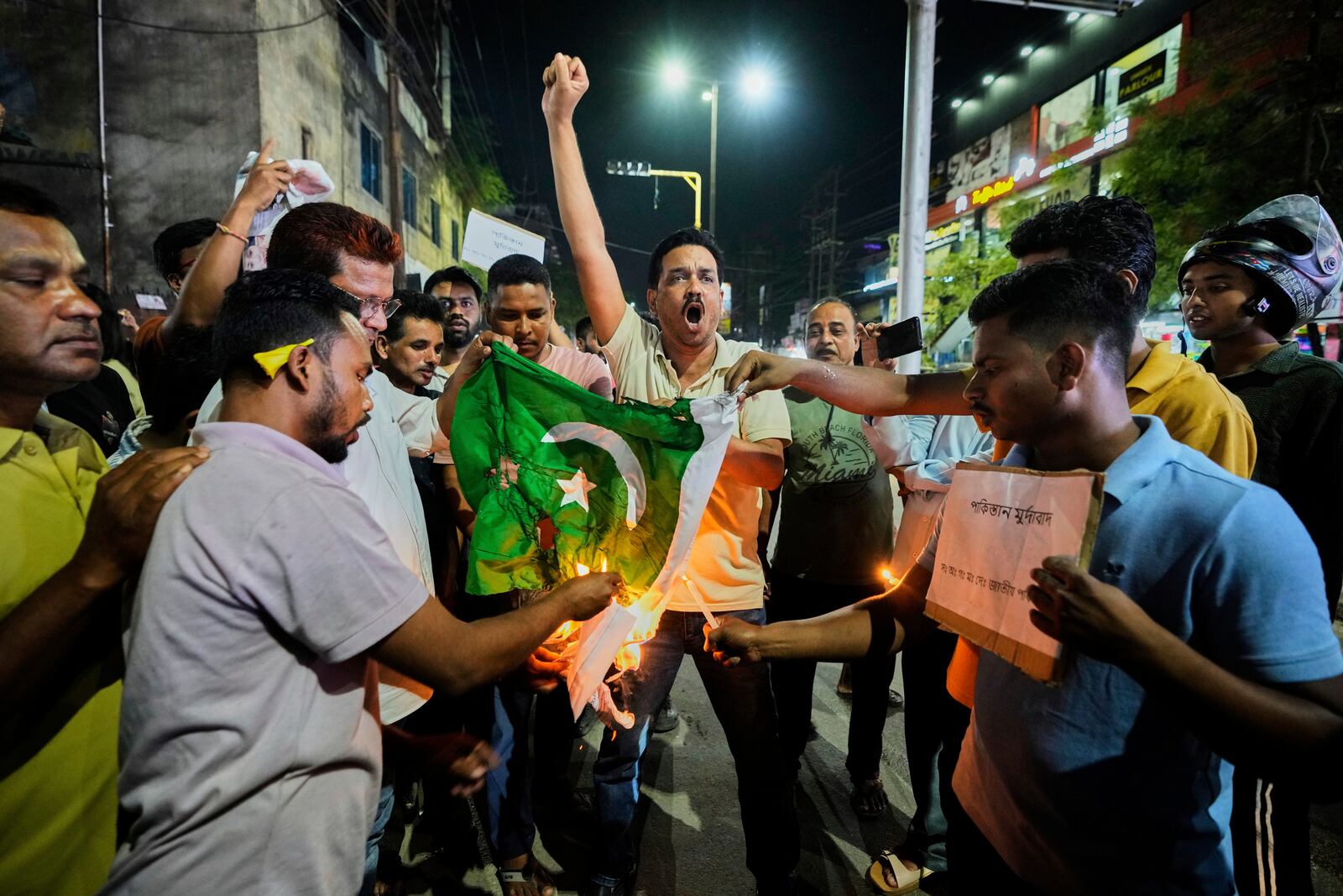 People burn a Pakistani flag in protest against the killing of tourists by militants a day after militants indiscriminately opened fire on tourists near Pahalgam in Indian controlled Kashmir, in Guwahati, India, Wednesday, April 23, 2025. (AP Photo/Anupam Nath)