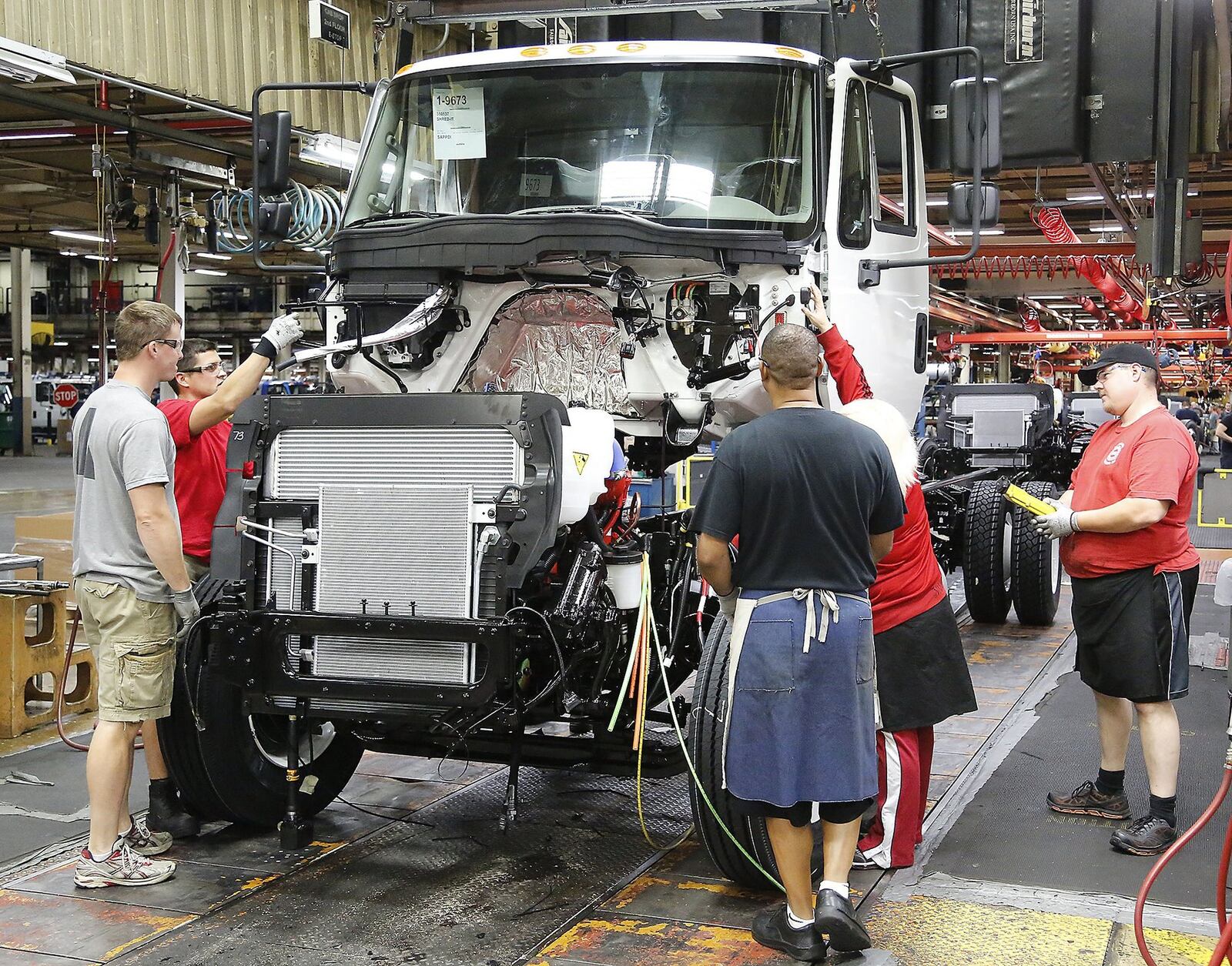 Workers at Navistar assemble a truck cab. Bill Lackey/Staff