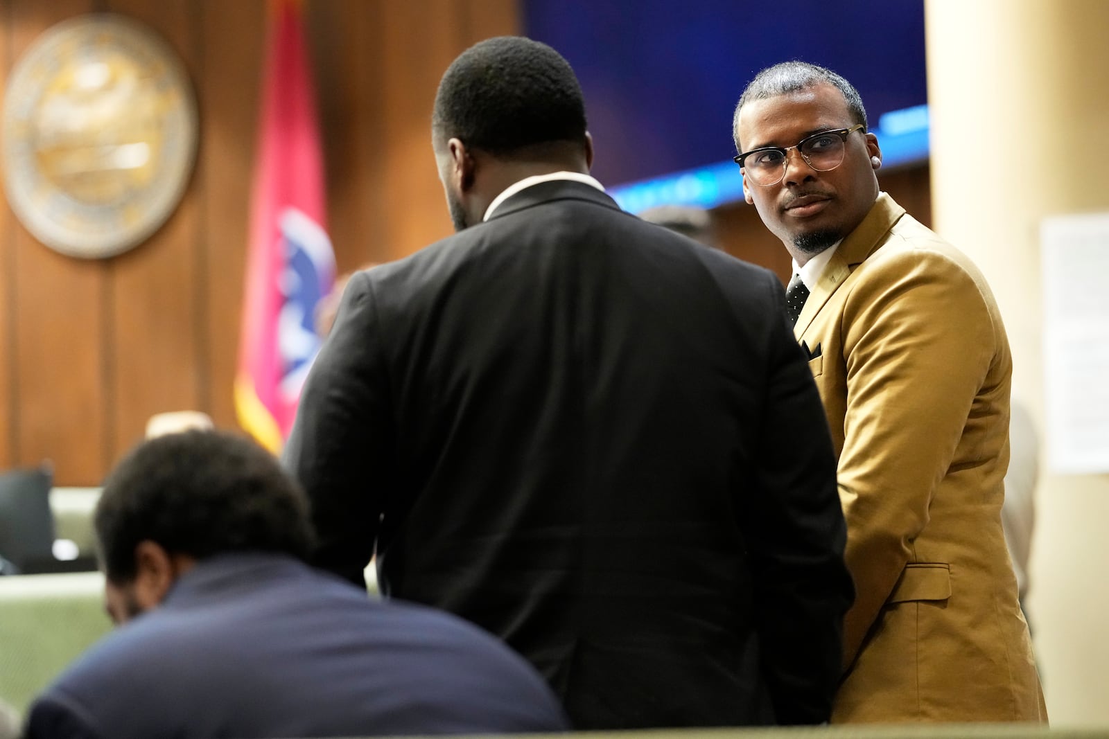 Former Memphis Police Officer Justin Smith Jr., right, one of three former Memphis officers charged with fatally beating Tyre Nichols in 2023, stands in the courtroom with his fellow defendants Tedarrius Bean, center, and Demetrius Haley, left, during break in the trial Wednesday, April 30, 2025, in Memphis, Tenn. (AP Photo/George Walker IV, Pool)