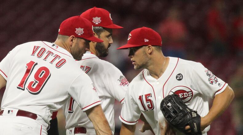 Reds players (left to right) Joey Votto, Eugenio Suarez and Nick Senzel celebrate after a victory against the Angels on Tuesday, Aug. 6, 2019, at Great American Ball Park in Cincinnati. David Jablonski/Staff