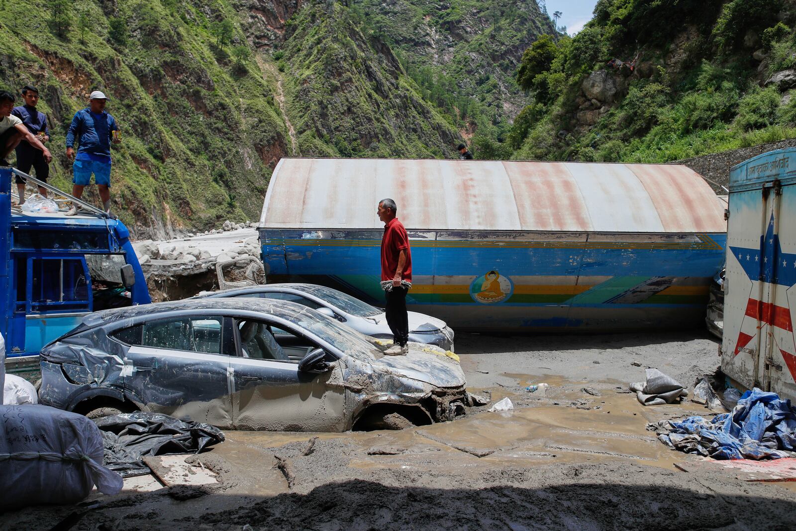 Damaged vehicles are seen after severe monsoon rains flooded the Bhotekoshi River and swept away a key bridge connecting the country with China at Rasuwagadi,120 kilometers (75 miles) north of the capital, Kathmandu, Nepal, Wednesday, July, 9, 2025. (AP Photo/Sujan Gurung)