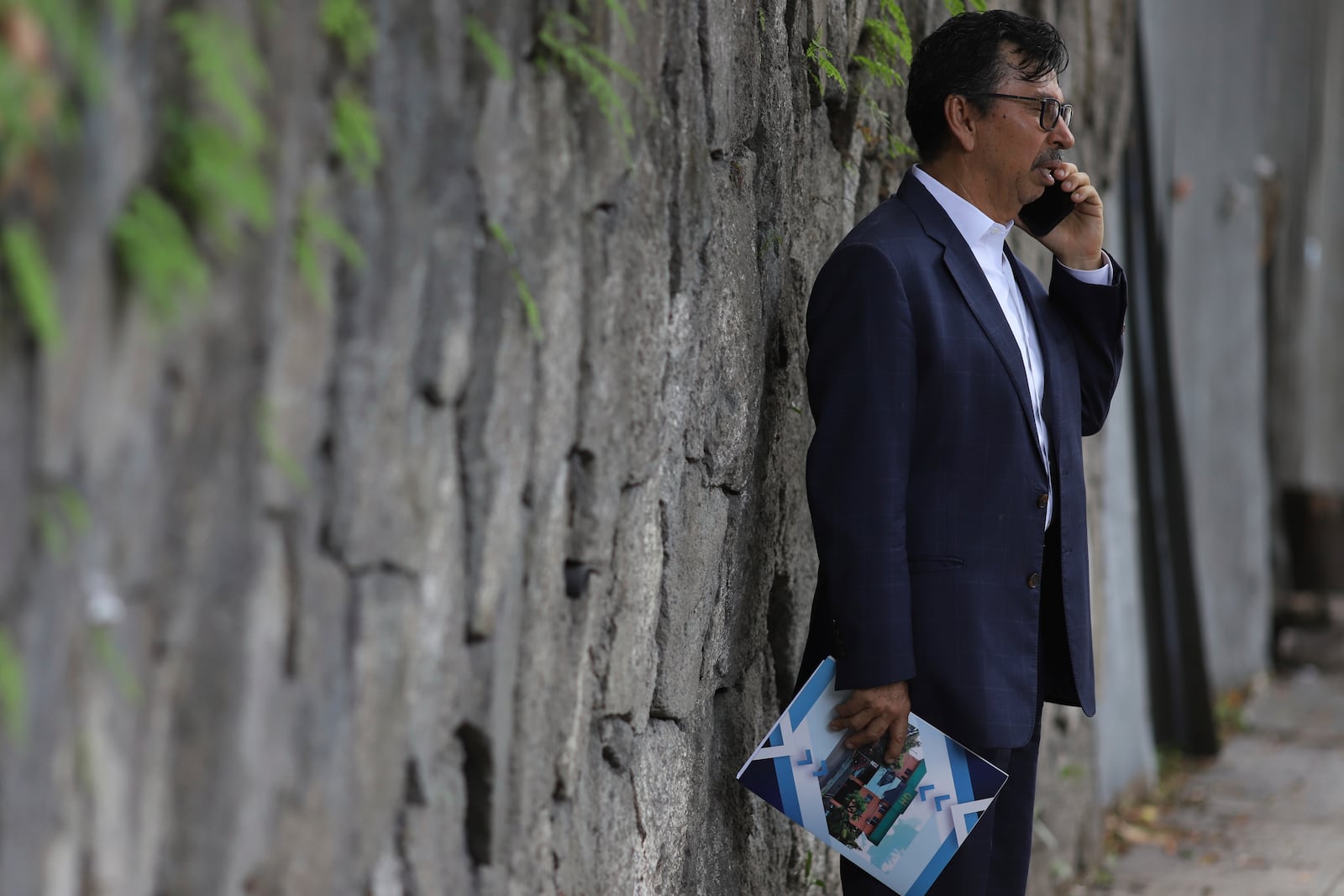 Jaime Quintanilla, attorney for Salvador Enrique Anaya, a critic of President Nayib Bukele's government, speaks on his cell phone outside a police station after arriving to visit his client in San Salvador, Tuesday, June 10, 2025. Anaya was detained on June 7 for alleged money laundering and asset laundering. (AP Photo/Salvador Melendez)
