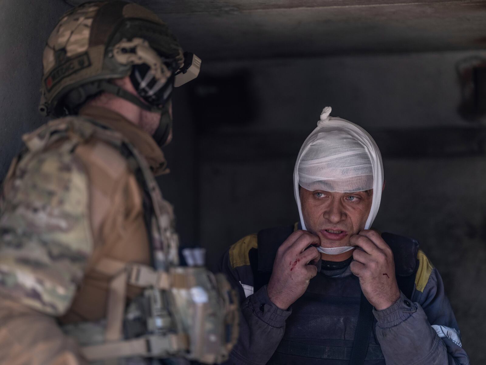 In this photo provided by Ukraine's 93rd Kholodnyi Yar Separate Mechanized Brigade press service, a police medic gives first aid to an electrician who was injured by a guided aerial bomb while repairing energy equipment in Kostyantynivka, the site of heavy battles with Russian troops, in the Donetsk region, Ukraine, Saturday, April 19, 2025. (Iryna Rybakova/Ukraine's 93rd Mechanized Brigade via AP)