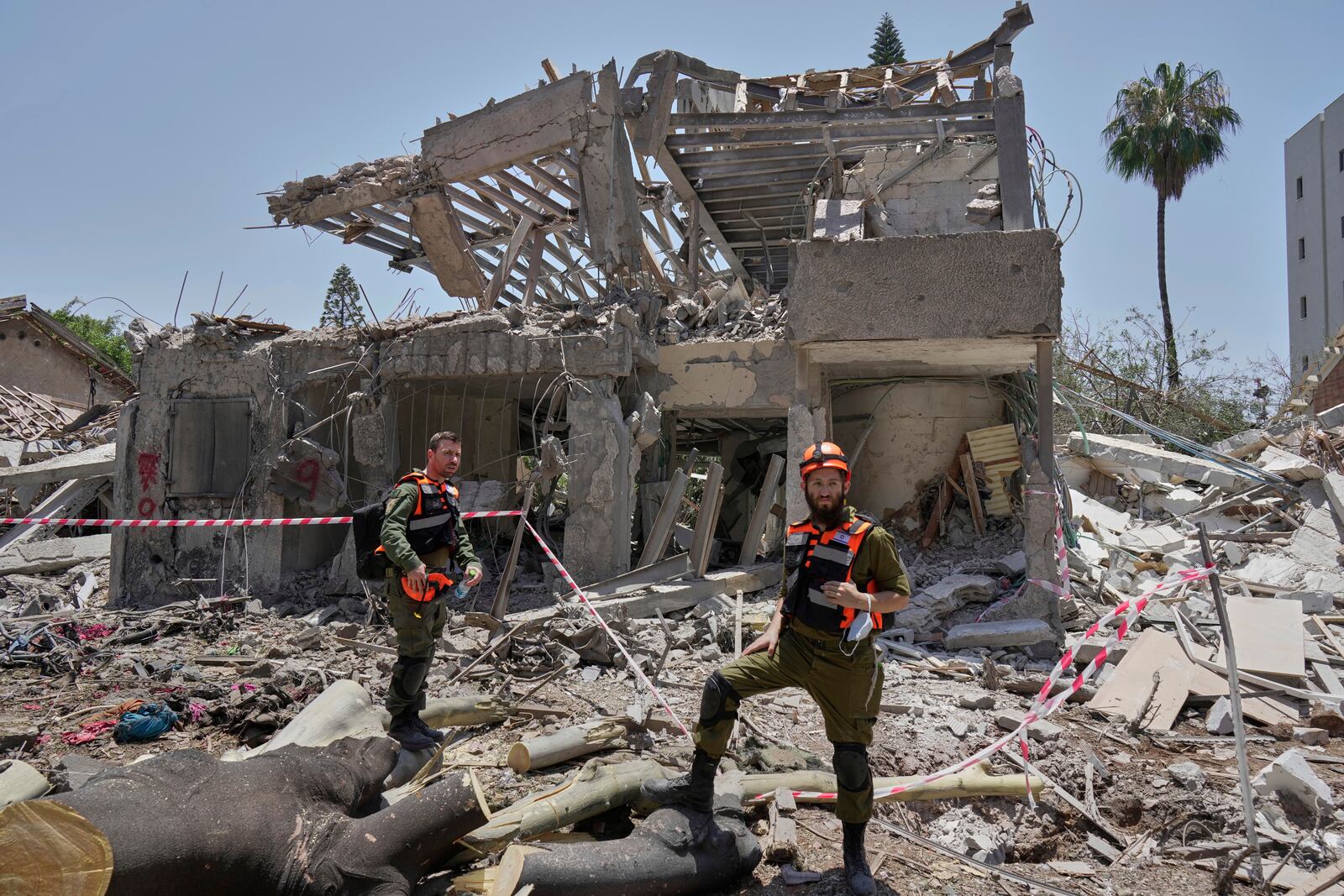 Israeli soldiers inspect the site struck by a direct missile strike launched from Iran in Tel Aviv, Israel, on Sunday, June 22, 2025. (AP Photo/Bernat Armangue)