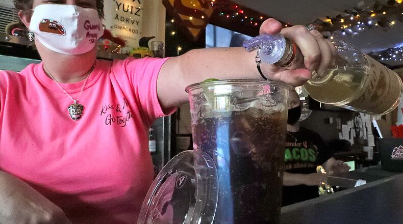 Shelley Kenbeek mixes a drink in a to-go cup at Guerra Krazy Taco Wednesday. BILL LACKEY/STAFF