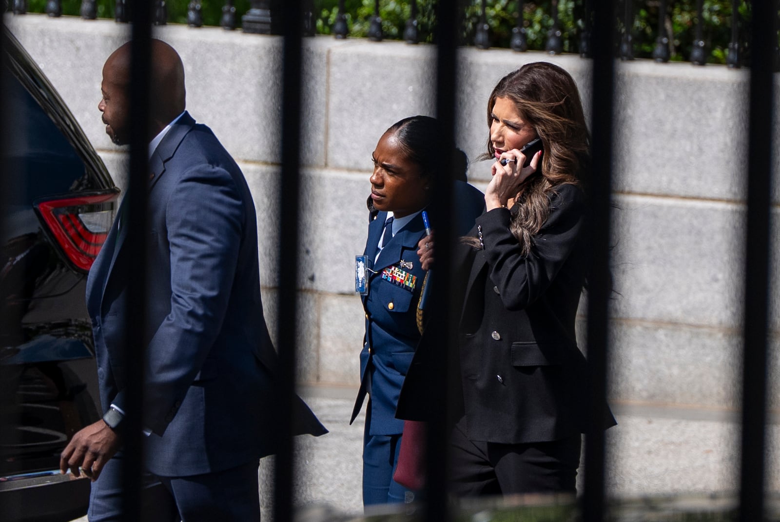 Homeland Security Secretary Kristi Noem, right, walks to the White House, Wednesday, April 30, 2025, in Washington. (AP Photo/Alex Brandon)