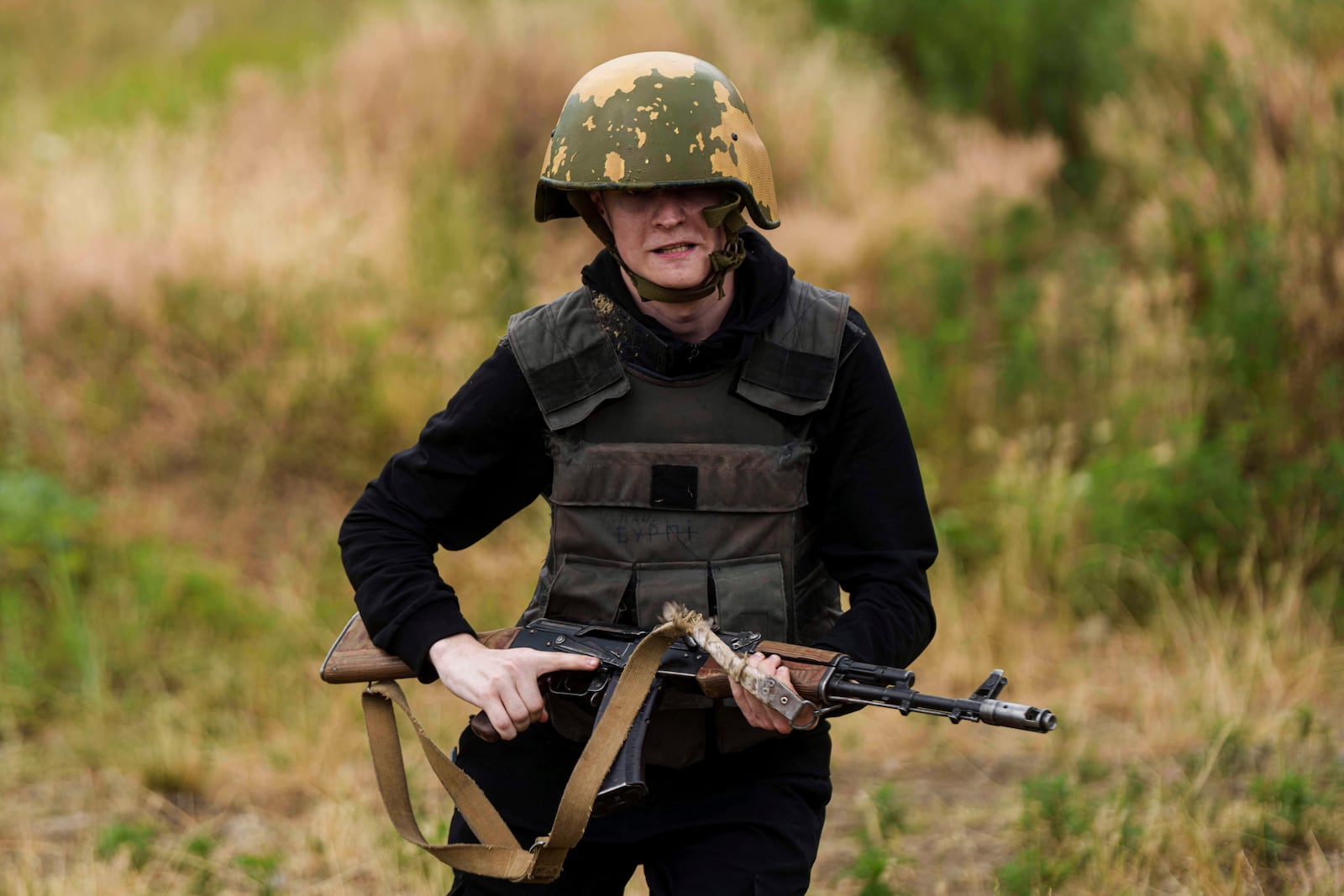 A Ukrainian 3rd Assault Brigade recruit runs to take a position during a training at the polygon in Kyiv region, Ukraine, on Wednesday, July 16, 2025. (AP Photo/Evgeniy Maloletka)