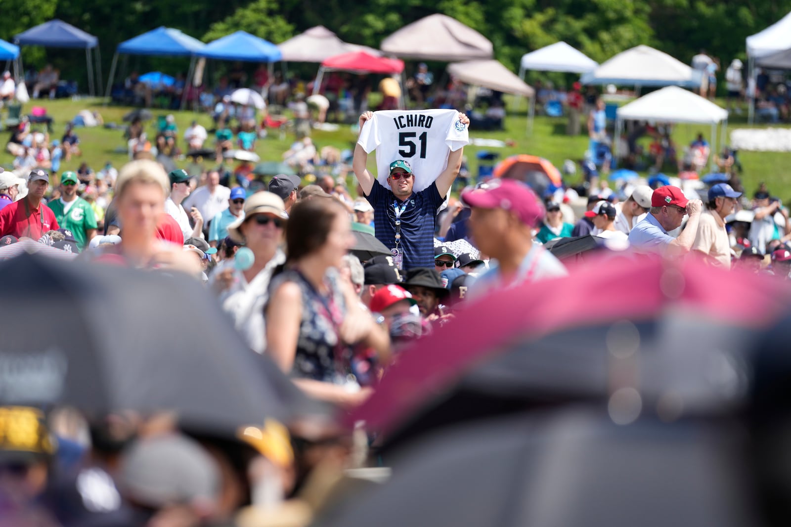 A man holds up an Ichiro Suzuki jersey before the National Baseball Hall of Fame induction ceremony in Cooperstown, N.Y., Sunday, July 27, 2025. (AP Photo/Seth Wenig)