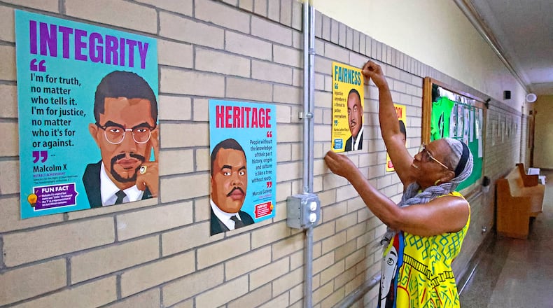 Jeannette Anderson, office manager at the Springfield Sports Academy, hangs pictures with messages on them in the hallway at the school Tuesday, July 30, 2024. The Springfield Sports Academy is getting ready to start their second year. BILL LACKEY/STAFF